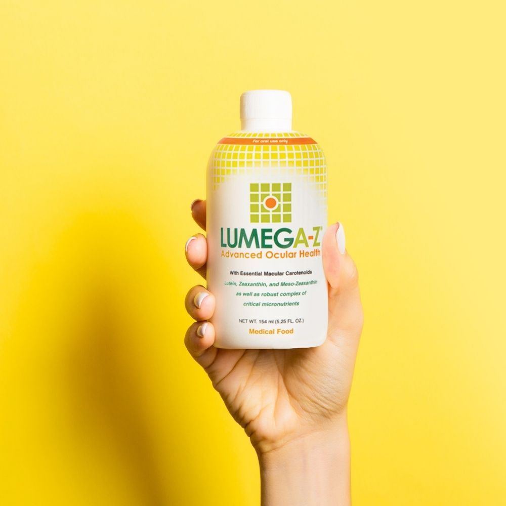 Lumega-Z Liquid Vitamins for Eye Health with hand holding the bottle